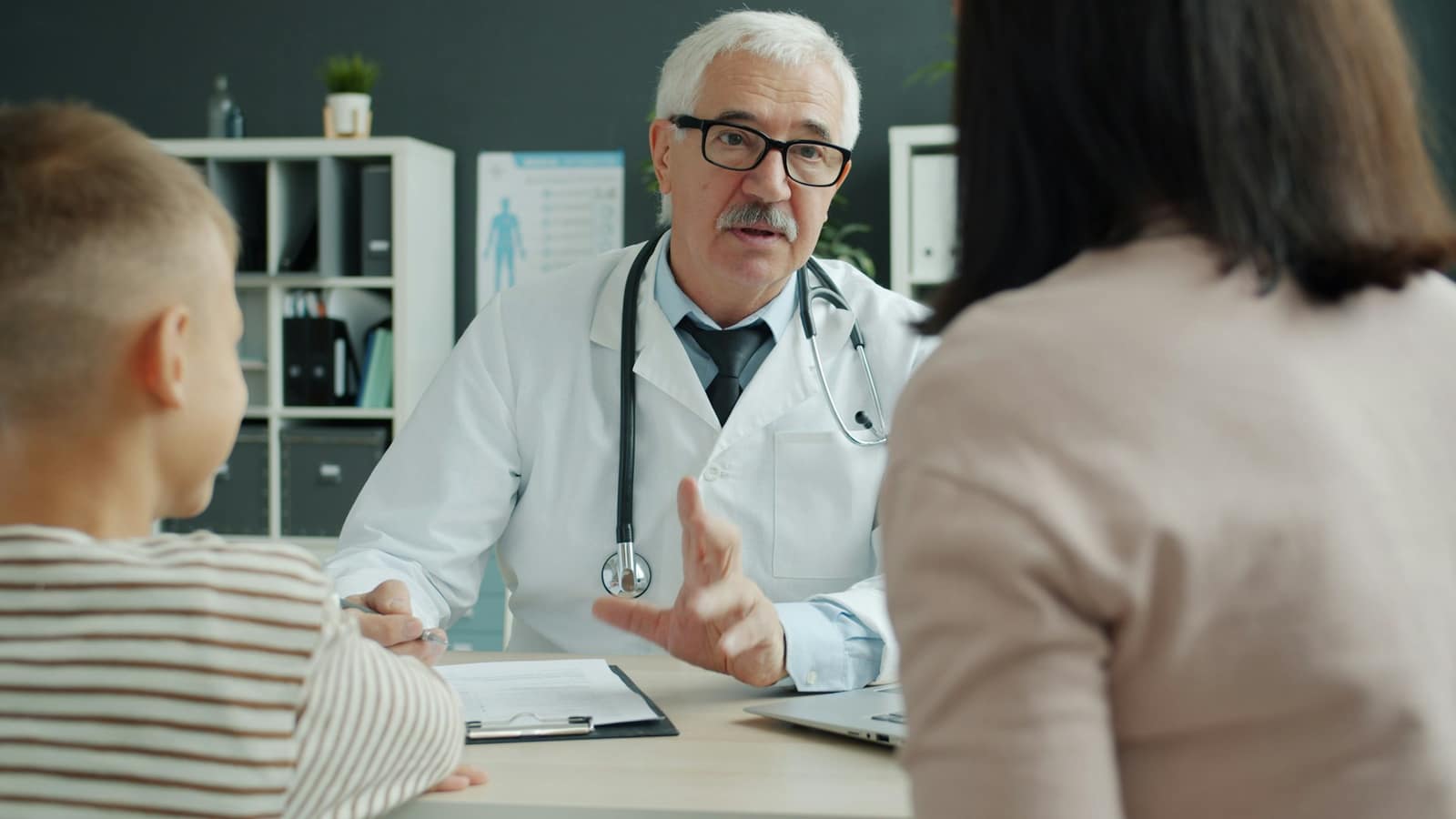 Doctor talking with a mother and child in a clinic office